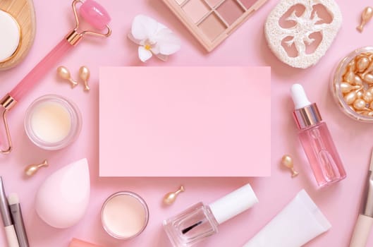 Paper card between skin care and decorative cosmetics on pink, top view, mockup. Flat lay with natural beauty products and decorative cosmetics. Everyday woman face care routine