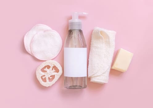 One pump Cosmetic bottle and eco-friendly skin care accessories on pink flat lay, copy space. Top view of natural beauty products for hair and skin care