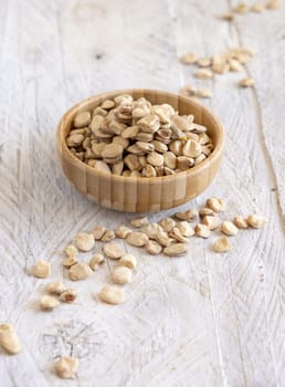 Bowl of raw dry Grass pea close up on wood. Healthy, protein source for vegan and vegetarian diet. Traditional Italian apulian cuisine ingredient. Legumes known as Cicerchia, Vetch, Blue Sweet Pea