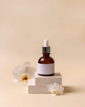 Brown glass dropper bottle on stone near white orchid flowers on light yellow, close up, mockup. Skincare handmade beauty product, serum or lotion. Exotic natural cosmetics..