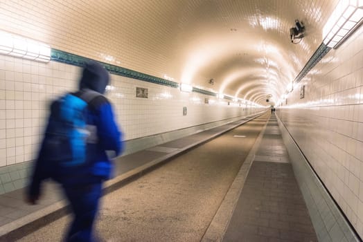 people walk through the old elbtunnel in hamburg in the underground of the elb