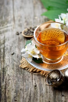 Jasmine and green tea in tea cup on wooden table.