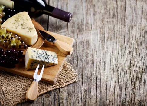 Wine, cheese and grape on rustic wooden table