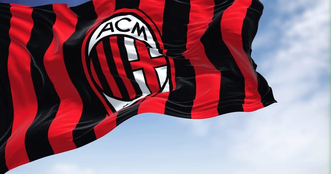 Milan, Italy, July 2022: The flag of A.C. Milan waving in the wind on a clear day. Milan is a professional football club based in Milan, Italy