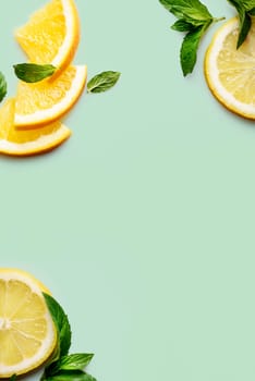 Citrus slices and mint herbs frame on retro mint background with copyspace
