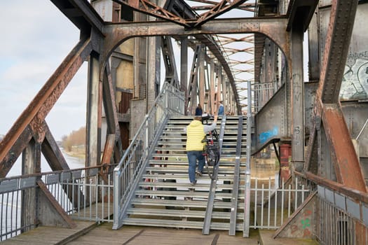 Pedestrians crossing the dilapidated lift bridge over the river Elbe near Magdeburg