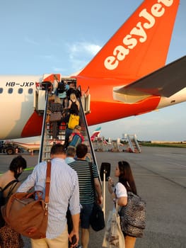 An easyJet aircraft at Hamburg Airport is being prepared for take-off. Passengers at the gate board the plane. Theme Image - Travel Photography