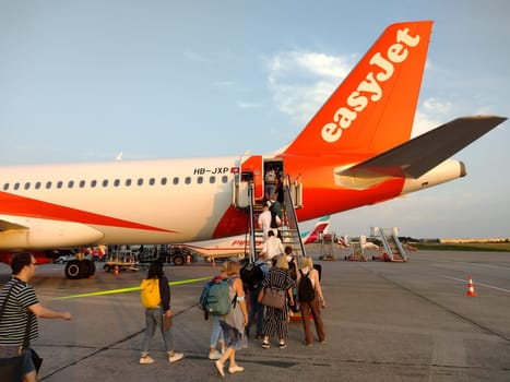 An easyJet aircraft at Hamburg Airport is being prepared for take-off. Passengers at the gate board the plane. Theme Image - Travel Photography