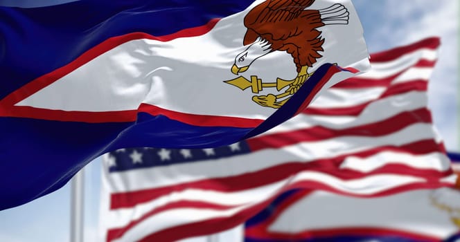 The American Samoa flags waving along with the national flag of the United States of America. American Samoa is an unincorporated territory of the United States located in the South Pacific Ocean