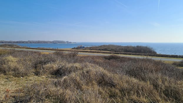 View of the resort of Port Zelande and its surroundings of the lake and dunes under a partly blue sky