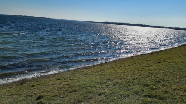 View of the resort of Port Zelande and its surroundings of the lake and dunes under a partly blue sky
