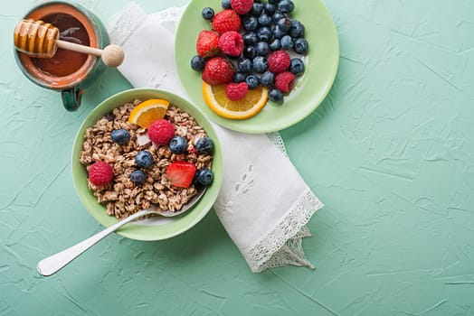 A bowl of dry granola served with fresh berry fruit. Oatmeal plate. Healthy food, diet. Top view.