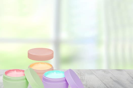 Closeup of various colorful cosmetic jars of concealer cream, moisturising cream on a table over abstract blurred windows background. Space for design. Cosmetic labels. Advertising.