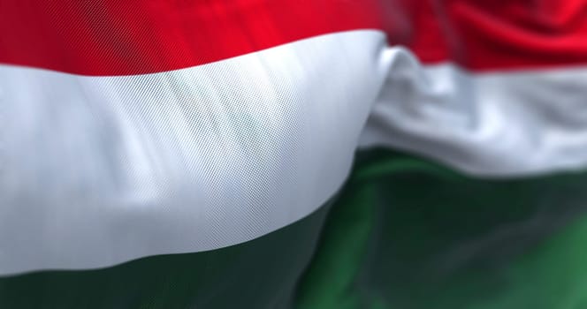 Close-up view of the Hungary national flag waving in the wind. Hungary is a landlocked country in Central Europe. Fabric textured background. Selective focus