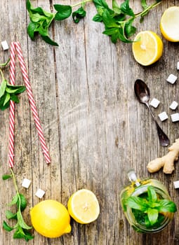 Top view of refreshing cocktail ingredients on wooden background with copyspace.Recipe for detox juice with lemonade, ginger and mint in retro mason jar.