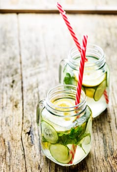 Healthy eating lifestyle concept. Detox lemonade with cucumber and mint in retro mason jar glass on wooden table with copyspace.