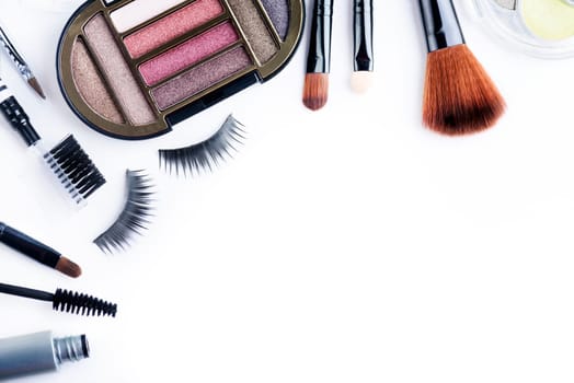 Professional makeup set isolated over white background. Eye shadows, brushes, mascara, eye lushes and various fashion make up tools