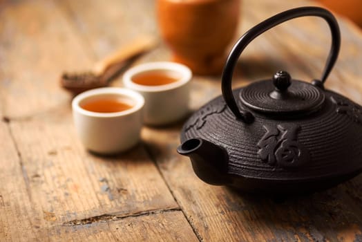Traditional japanese herbal tea recipe prepared in cast iron teapot with organic dry herbs.