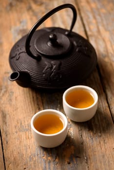 Traditional japanese herbal tea recipe prepared in cast iron teapot with organic dry herbs.