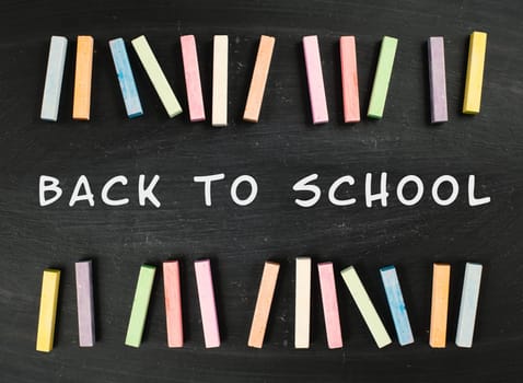 Chalkboard with the text back to school, education concept, colorful chalk