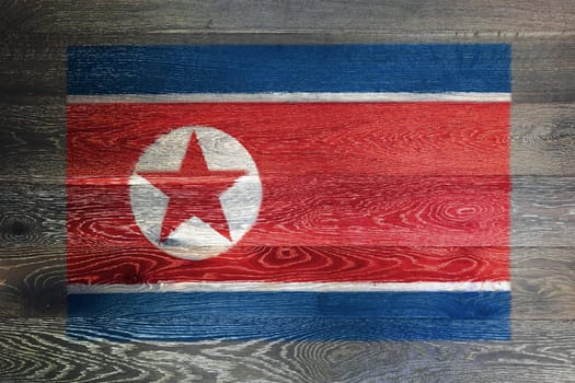 A North Korea flag on rustic old wood surface background