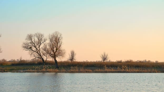 the season after winter and before summer, in which vegetation begins to appear. Beautiful sunset on the river in early spring