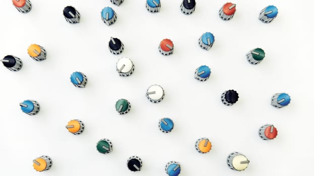a small disk or knob sewn on to a garment, either to fasten it by being pushed through a slit made for the purpose or for decoration.Amplifier mixer buttons in chaotic order on white background.