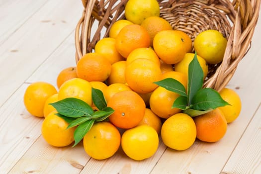 fresh tangerines in a basket on wooden background