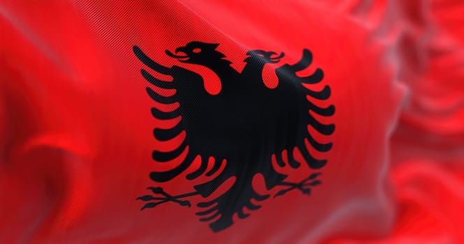Close-up view of the Albanian national flag waving in the wind. Albania is a country in Southeastern Europe. Fabric textured background. Selective focus