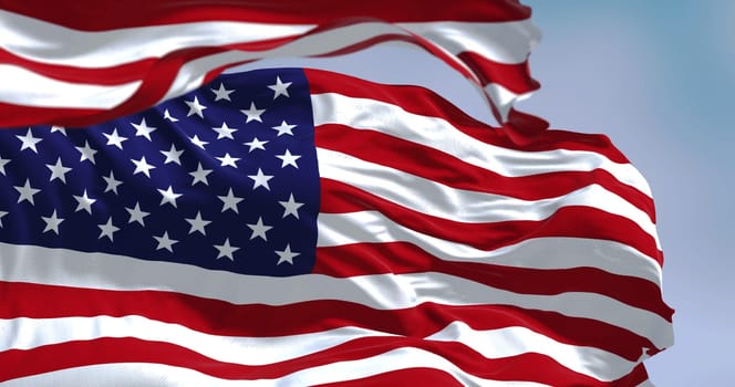 Flags of the United States of America waving in the wind. Clear sky in the background. Selective focus. Democracy, independence and election day. Patriotic symbol of American pride