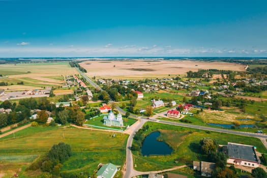 Porplishte, Dokshitsy District, Vitsebsk Region, Belarus. Old Wooden Church of Transfiguration And Catholic Church Of Virgin Mary In Autumn Day. Aerial View.