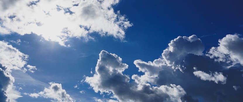 Blue sky with clouds and sun shines bright in the daytime in summer