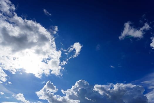 Blue sky with clouds and sun shines bright in the daytime in summer