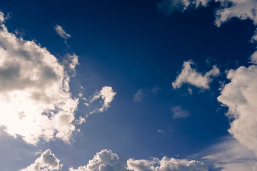 Blue sky with clouds and sun shines bright in the daytime in summer