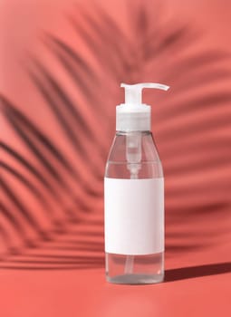 One pump Plastic bottle with blank label on pink, palm leaf hard shadows, close up, mockup. Skincare beauty product, facial cleaner or lotion. Natural cosmetics..