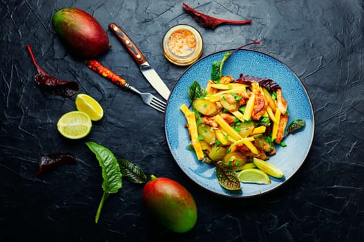 Diet salad with chicken and ripe mango. Meat salad on the plate