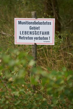 Prohibition sign in a forest in Germany. Translation: ammunition contaminated area, danger to life, no trespassing