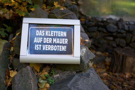 Prohibition sign in a park in Germany. Translation: Climbing the wall is forbidden
