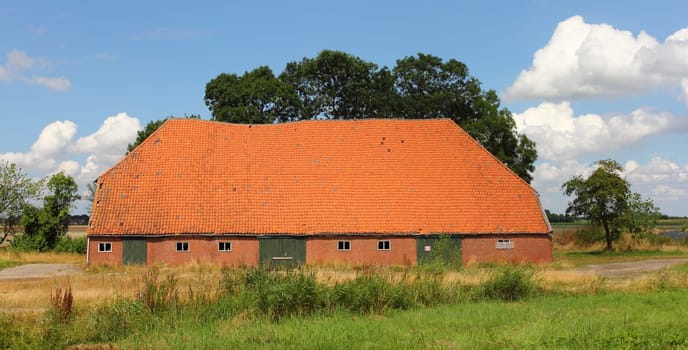 Big agricultural building, blue sky in background.großes Landwirtschaftliches Gebäude, blauer Himmel im Hintergrund.
