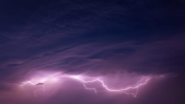Bright Lightning On Purple Night Sky During Hunderstorm.