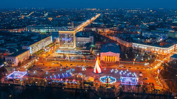 Gomel, Belarus. Main Christmas Tree And Festive Illumination On Lenin Square In Homel. New Year Celebration In Belarus. Aerial Night View.