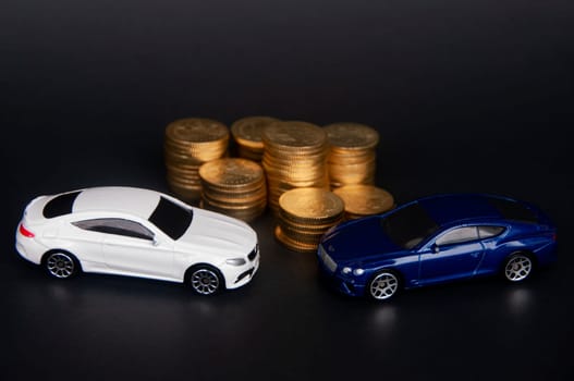 Kuala Lumpur, Malaysia - July 2022 : Miniature toy car of Mercedes AMG and Bentley Continental GT with gold coins on black cover background. Wealth concept