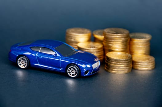 Kuala Lumpur, Malaysia - July 2022 : Miniature toy car of Bentley Continental GT with gold coins on black cover background. Copy space.