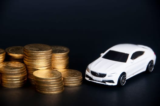 Kuala Lumpur, Malaysia - July 2022 : Miniature toy car of Mercedes AMG with gold coins on black cover background. Copy space