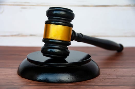 Side view of gavel on wooden table background. Justice and law concept.