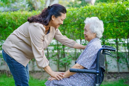 Caregiver help Asian elderly woman disability patient in nursing hospital, medical concept.