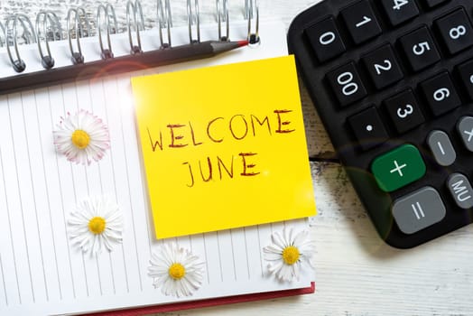 Sign displaying Welcome June, Business overview Calendar Sixth Month Second Quarter Thirty days Greetings Note With Important Message Over Notebook With Flowers Around.