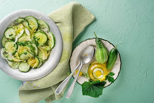 Cucumber salad. Preparation of fresh cucumber salad on green background
