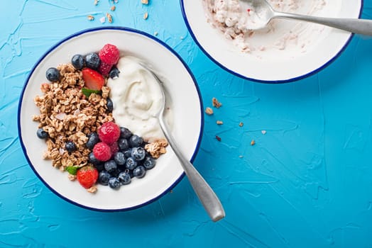 A plate of dry granola served with fresh berry fruit and yogurt. Oatmeal plate. Healthy food, diet. Top view.