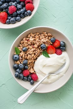 A plate of dry granola served with fresh berry fruit and yogurt. Oatmeal plate. Healthy food, diet. Top view.